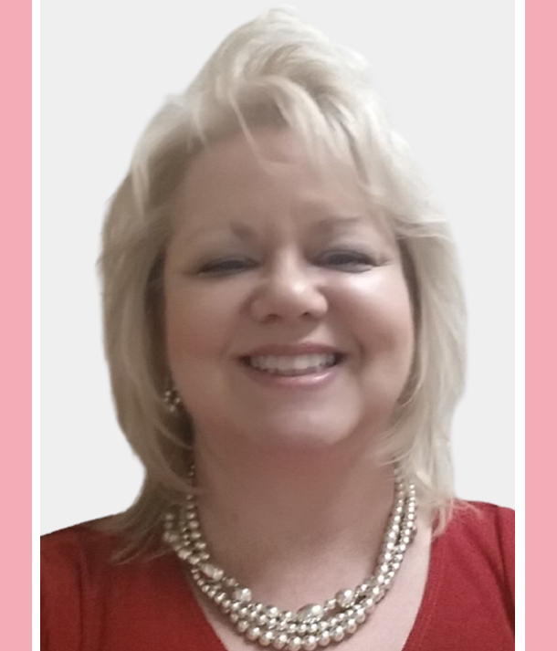 A woman with white hair wearing pearls and red.