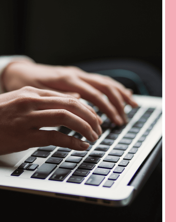 A person typing on a laptop keyboard.