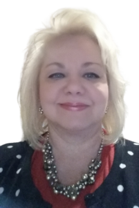 A woman with blonde hair and polka dot necklace.